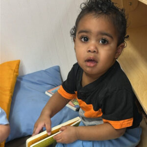 a toddler holding a book