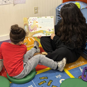 A woman reading aloud to a child