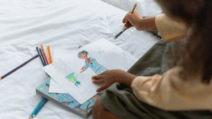 child drawing a picture of her teacher
